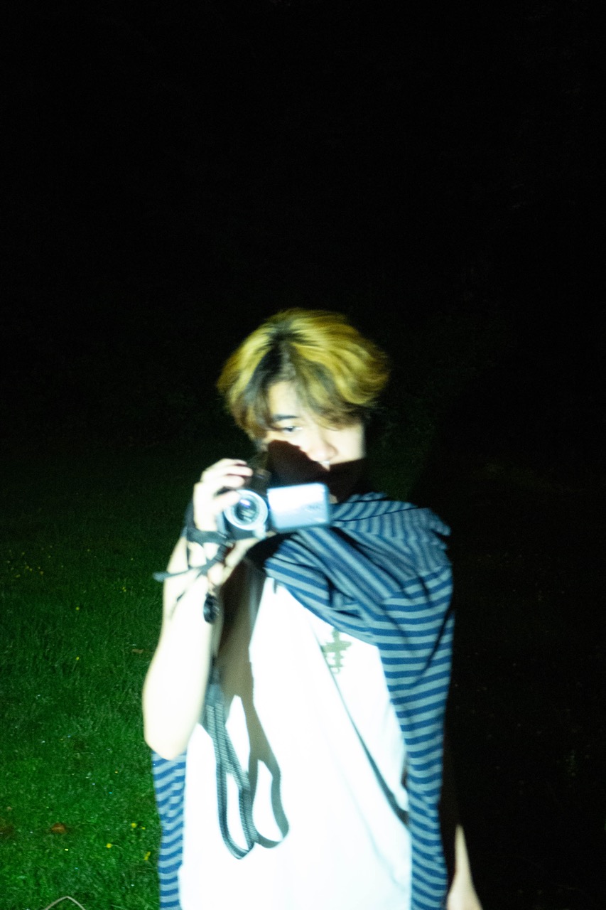 A photo of Andy Chau holding a camcorder against a dark background